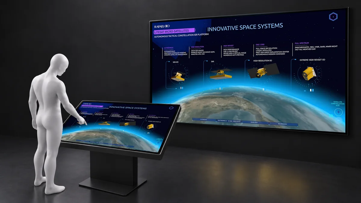 A visitor controls a Space Systems presentation on a smaller touchscreen while the same image appears on a large display.